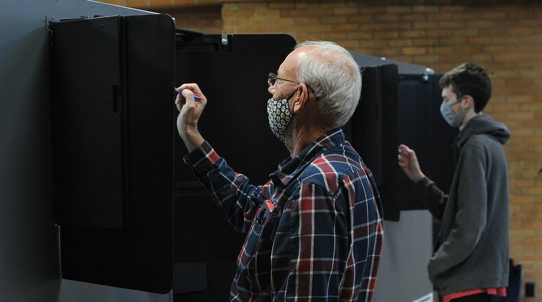David Turpin, left, looks over his ballot while voting Tuesday Nov. 2, 2021 at the Central Christian Church in Kettering. MARSHALL GORBY\STAFF