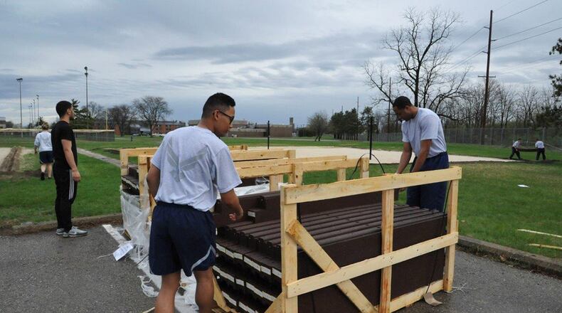 Airman Basic Paulo Eugenio (left) and Airman 1st Class Tyshon McDuffie, students assigned to the 737th training group, unload edging April 12 for the sand volleyball courts at Jarvis Fitness and Sports Complex in Area A at Wright-Patterson Air Force Base. The new edging is part of a series of upgrades to the facility. (U.S. Air Force photo/Senior Airman Holly Ardern)