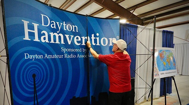 Rick Allnutt, ham radio call sign WS8G, sets up a display Wednesday, May 15, 2024 for this weekend's Hamvention at the Greene County Fairgrounds. Allnutt and Hamvention's international relations committee have a display to greet people from other countries so they feel comfortable at the event. MARSHALL GORBY \STAFF