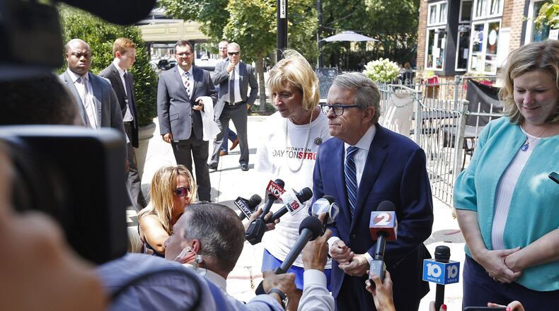 A security detail, top left, followed Governor Mike Dewine and Dayton Mayor Nan Whaley during a sidewalk press conference in the Oregon District on August 8. TY GREENLEES / STAFF