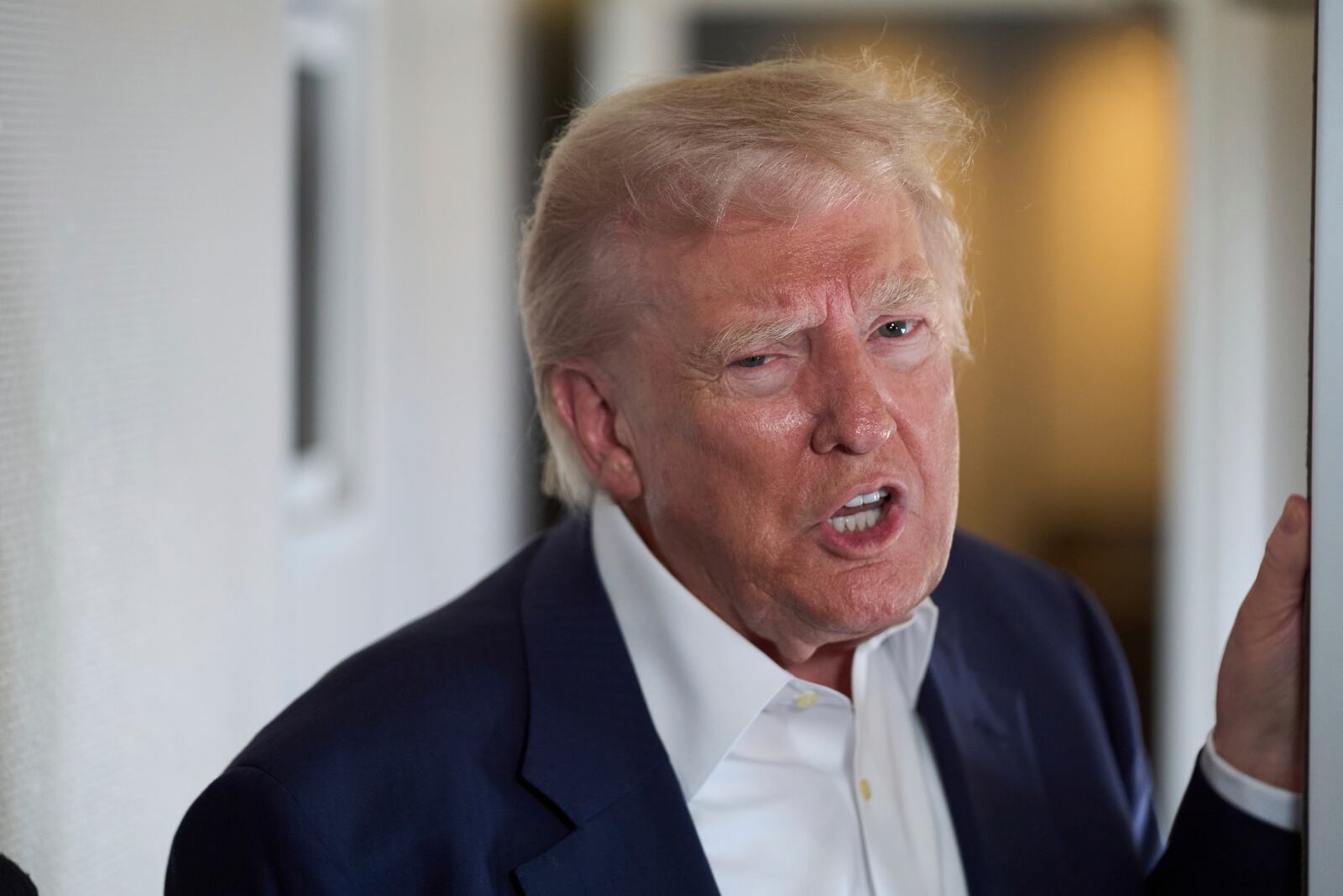 President Donald Trump speaks with reporters on Air Force One as he travels to attend the funeral of Pope Francis, Friday, April 25, 2025, in Rome. (AP Photo/Evan Vucci)
