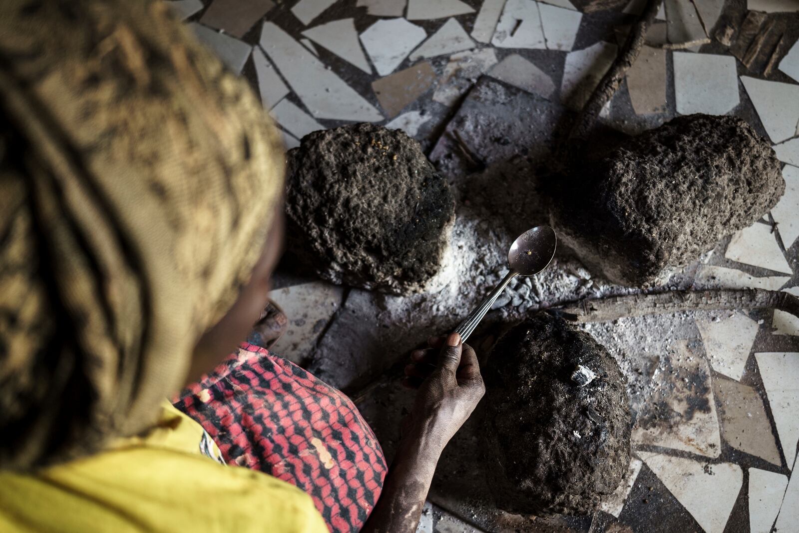 Without using protective equipment, Sadio Camara, a gold processor, vaporizes mercury to separate and retrieve gold at her home in the Kedougou region of Senegal on Thursday, Jan. 16, 2025. (AP Photo/Annika Hammerschlag)