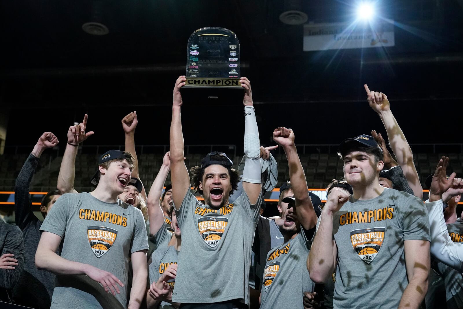 Wright State's Tanner Holden holds up the trophy and celebrates with teammates following an NCAA college basketball game against Northern Kentucky for the Horizon League men's tournament championship Tuesday, March 8, 2022, in Indianapolis. Wright State won 72-71. (AP Photo/Darron Cummings)