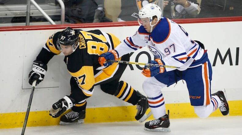 In this Nov. 8, 2016, file photo, Edmonton Oilers' Connor McDavid (97) and Pittsburgh Penguins' Sidney Crosby (87) battle for the puck during the first period of an NHL hockey game in Pittsburgh. Coming off back-to-back Conn Smythe Trophies as playoff MVP with the Stanley Cup champion Penguins, Crosby is widely considered by his peers as the best player in hockey. Crosby has just one true rival in that department: 20-year-old reigning MVP Connor McDavid, whose speed makes him a threat to be the NHL's best for the next decade or more. (AP Photo/Gene J. Puskar, File)