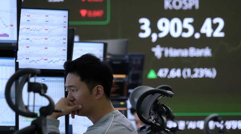 A currency trader watches monitors near a screen showing the Korea Composite Stock Price Index (KOSPI) at the foreign exchange dealing room of the Hana Bank headquarters in Seoul, South Korea, Wednesday, Nov. 26, 2025. (AP Photo/Ahn Young-joon)