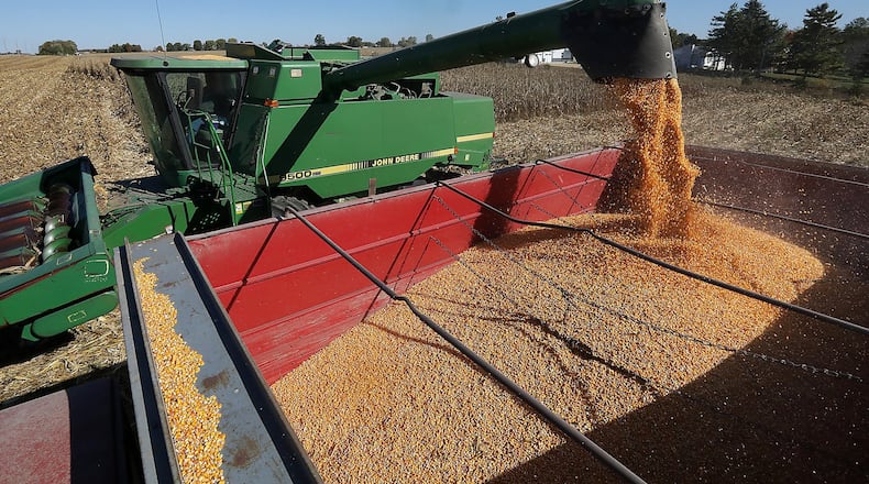 Bob Suver empties his corn harvest into a grain truck Wednesday along Detrick-Jordan Pike near New Carlisle. Even during a growing season when 1.5 million fewer acres of soybeans and corn were planted in Ohio, average farm incomes in the state are likely to increase compared to last year, according to an agricultural economist with The Ohio State University. BILL LACKEY/STAFF