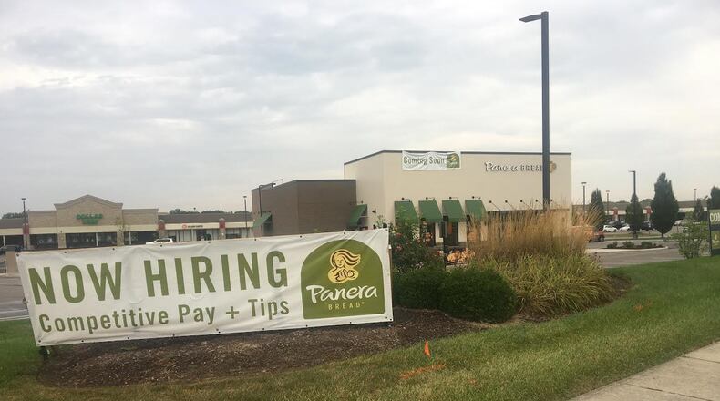 A "Coming Soon" sign hangs from a Panera Bread at the coroner of Lyons Road and Drexel Park Lane near Sam's Club.