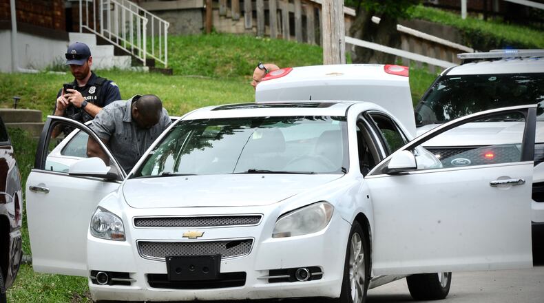 Dayton police search the car of a man who fired shots into the air Wednesday, June 8, 2022, in the 100 block of Marathon Avenue. MARSHALL GORBY/STAFF