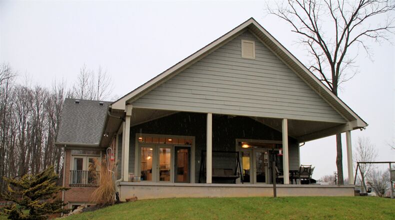 A paved driveway flanked by wooded areas leads to a circle drive near the side-entry garage of this custom-built home in Brookville. CONTRIBUTED PHOTOS BY KATHY TYLER