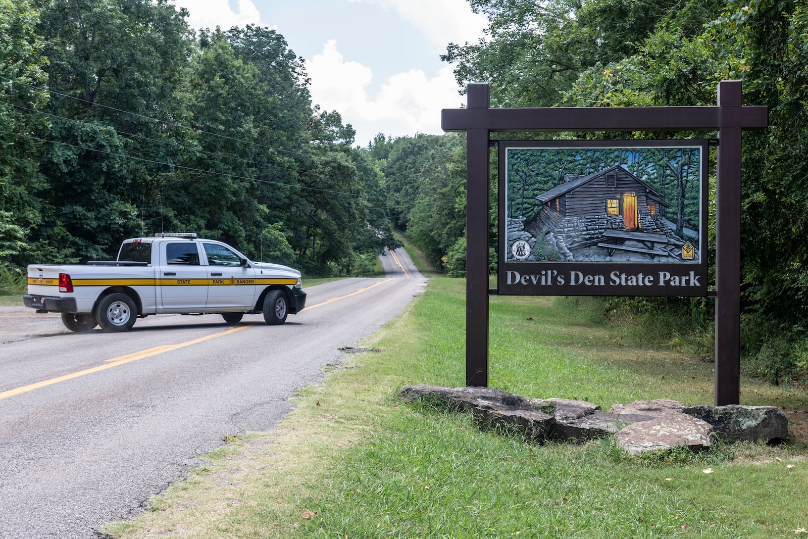 An Arkansas Park Ranger patrols the South Entrance of Devils Den State Park Monday, July 28, 2025, in West Fork, Ark. Police in Arkansas are searching for a suspect in the deaths of a couple who investigators said were attacked while on a wooded walking trail with their two young daughters. (AP Photo/Michael Woods)