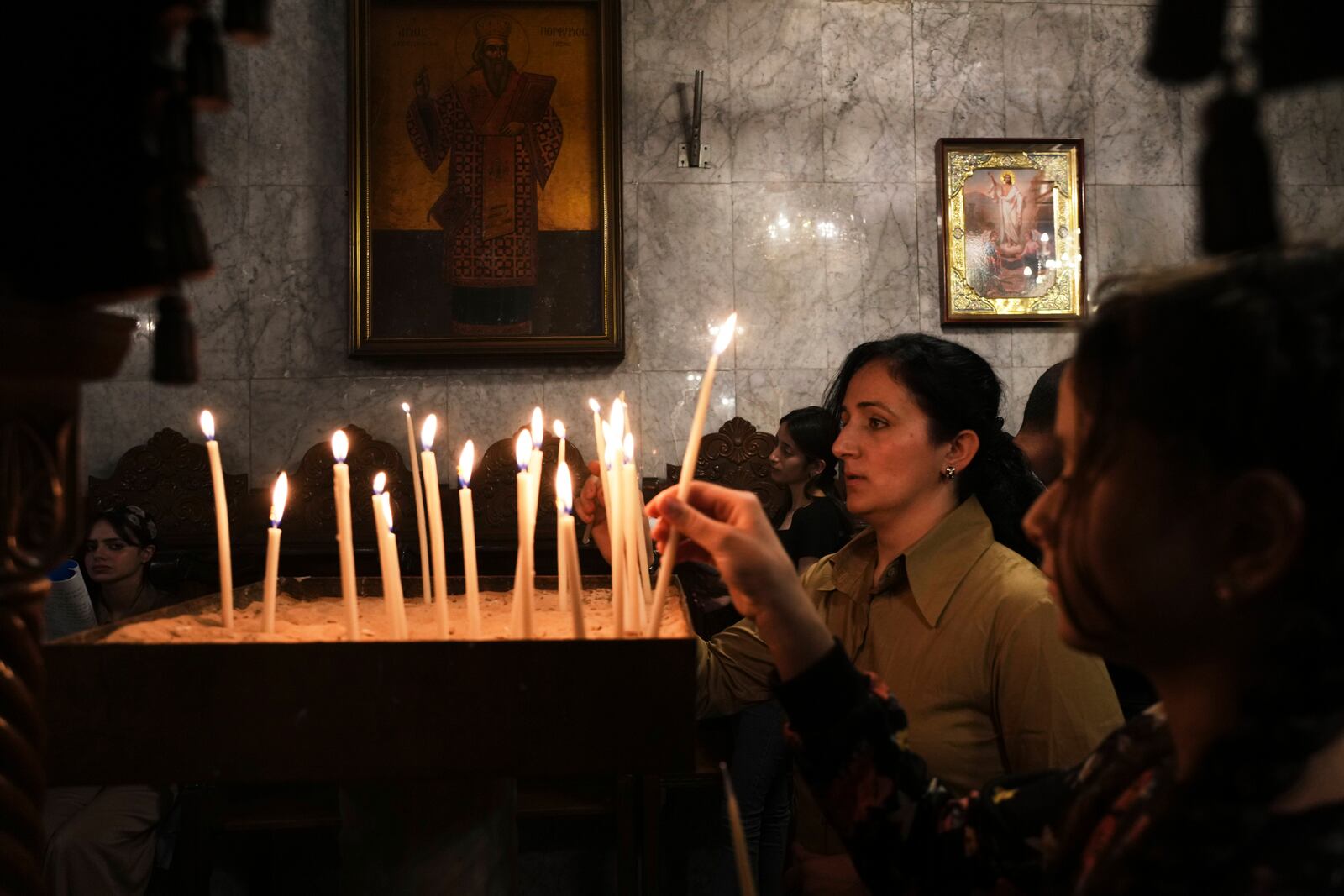 Palestinian Christians light candles during Good Friday mass at the Greek Orthodox Church of Saint Porphyrius in Gaza City, Friday, April 18, 2025. (AP Photo/Jehad Alshrafi)