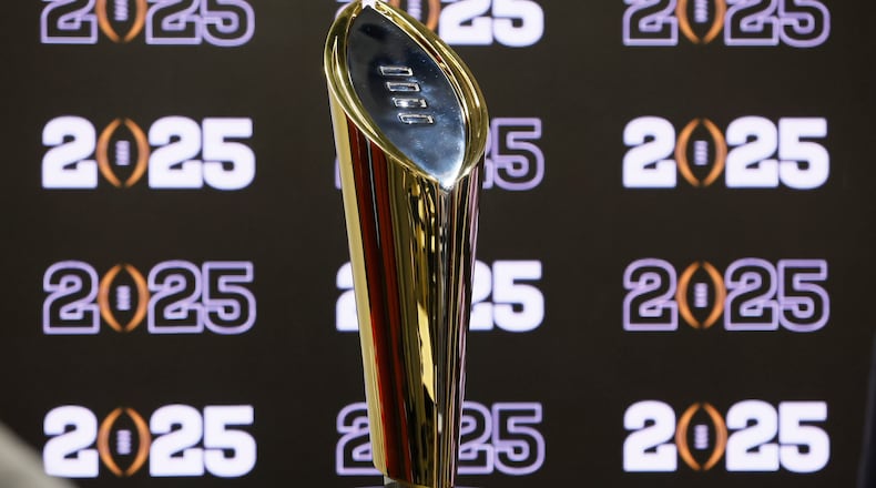 FILE - The National Championship Trophy is displayed following a news conference Aug. 16, 2022, in Atlanta, announcing that the CFP National Championship NCAA college football game will be played at Mercedes-Benz Stadium in 2025. The conference commissioners who manage the College Football Playoff met for almost seven hours Tuesday, Sept. 27, to work on expanding the postseason system from four to 12 teams as soon as the 2024 season. There is still much work to be done. (Jason Getz/Atlanta Journal-Constitution via AP, File)