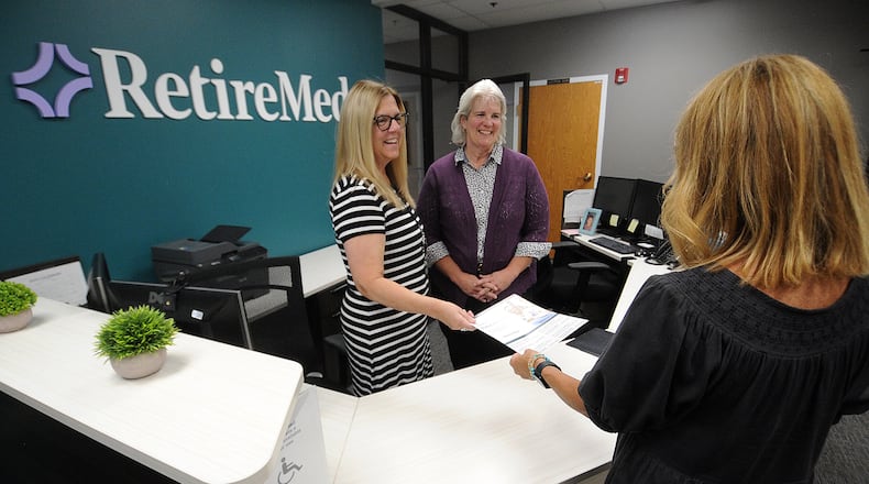 RetireMed staff from left, Mindy Berry and Cynthia Requarth talk with Becky Volz in their office located at 9080 Springboro Pike in Miamisburg. MARSHALL GORBY\STAFF