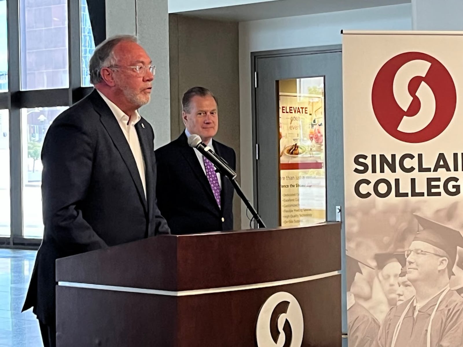 Sinclair Community College President Steven Johnson, at the podium, with U.S. Rep. Mike Turner, R-Dayton, on Wednesday, discussing recent confidential talks among Balkan nations at Sinclair. THOMAS GNAU/STAFF