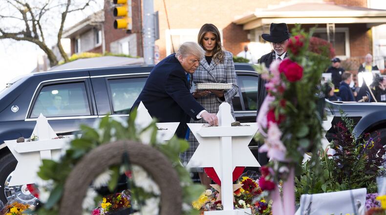 President Donald Trump, accompanied by first lady Melania Trump and Rabbi Jeffery Myers, lays a stone at the makeshift memorial outside the synagogue named Tree of Life in Pittsburgh on Tuesday, Oct. 30, 2018. The president, accompanied by his wife, daughter and son-in-law, arrived in Pittsburgh as the city began to bury the victims of Saturday’s synagogue attack. (Doug Mills/The New York Times)