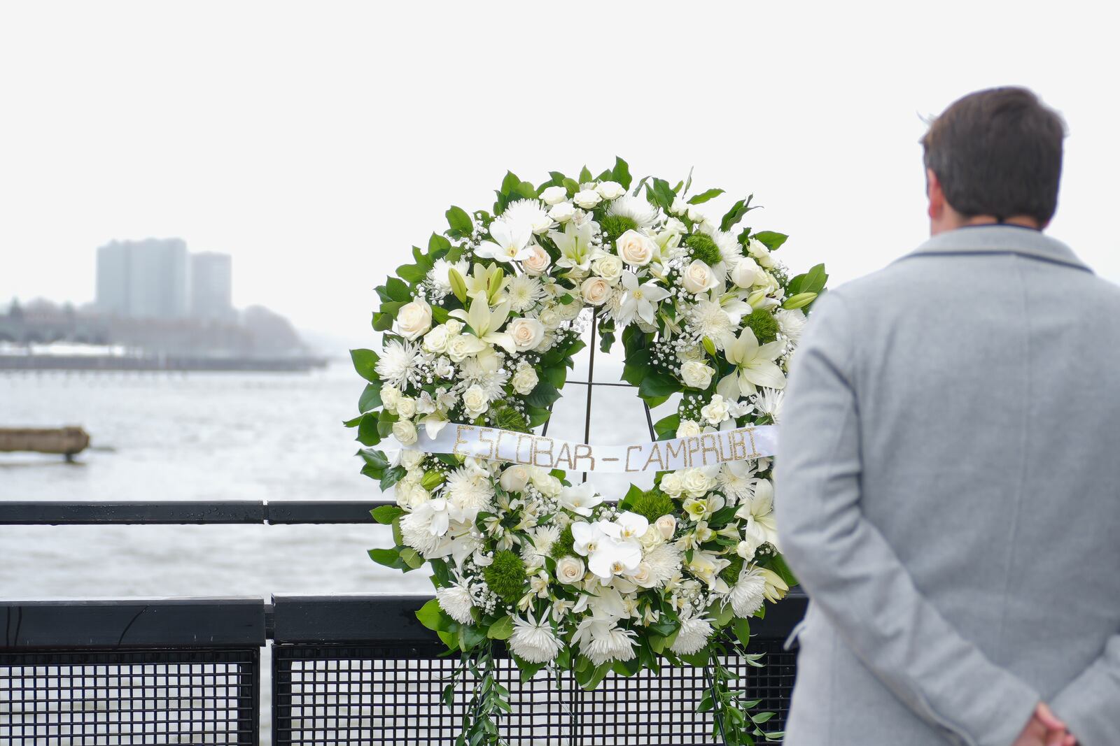 Joan Camprubí Montal, a family member of five of the victims who died in the Hudson River helicopter crash, looks at a memorial wreath on Saturday, April 12, 2025 in New York. (Justin Persaud/Mayoral Photography Office via AP)