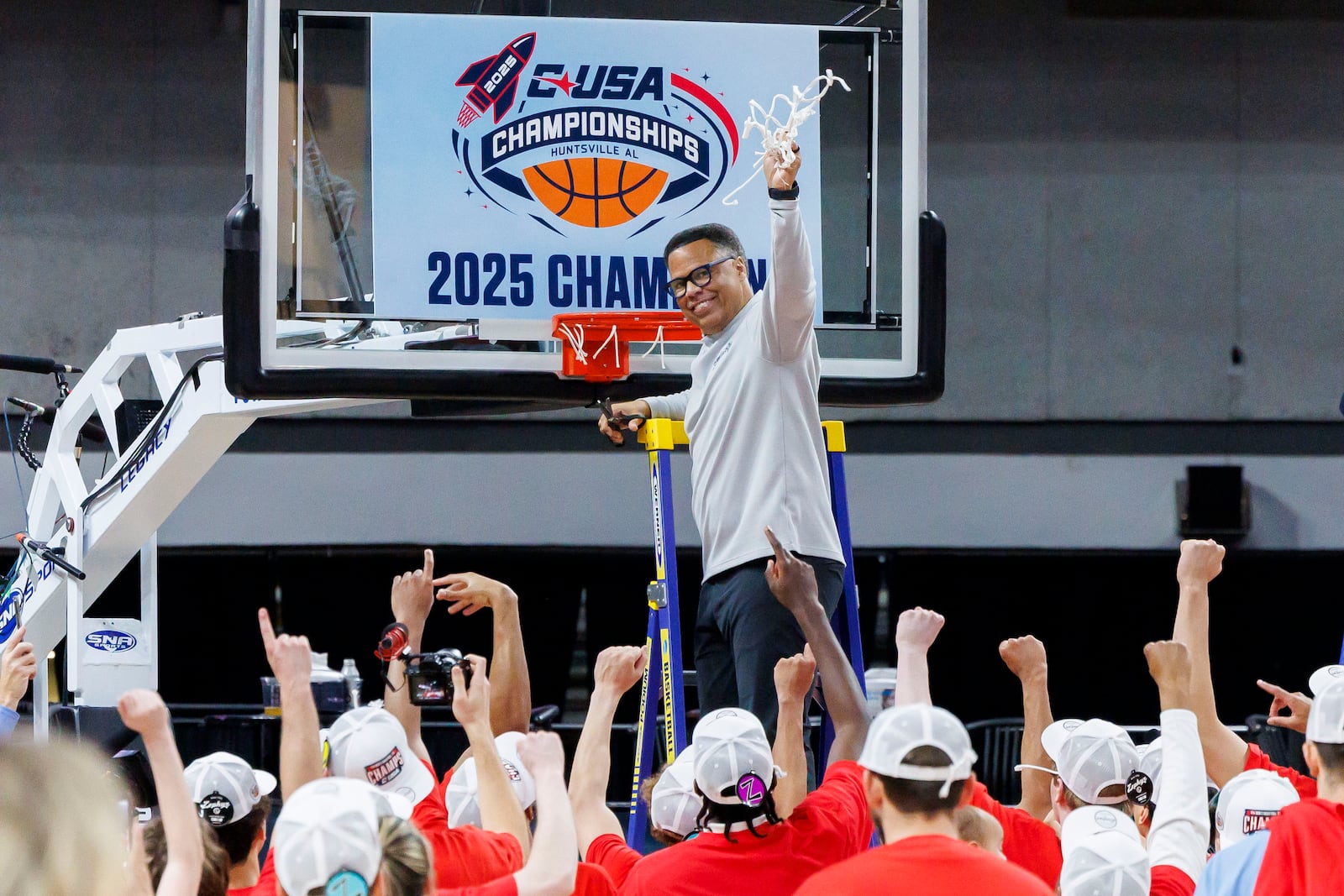 Liberty head coach Ritchie McKay, top, celebrates as he cuts down the second net after a win in an NCAA college basketball game against Jacksonville State in the championship of the Conference USA tournament Saturday, March 15, 2025, in Huntsville, Ala. (AP Photo/Vasha Hunt)