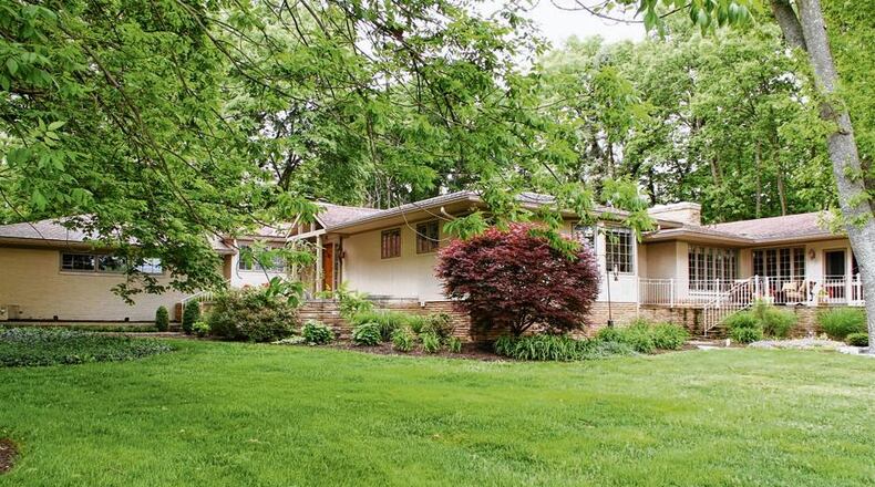 A manicured front lawn gives way to thickly-wooded areas, which provide a natural backdrop and privacy around this renovated and enlarged ranch home, which offers panoramic views of Moraine Country Club Golf Course across the street.