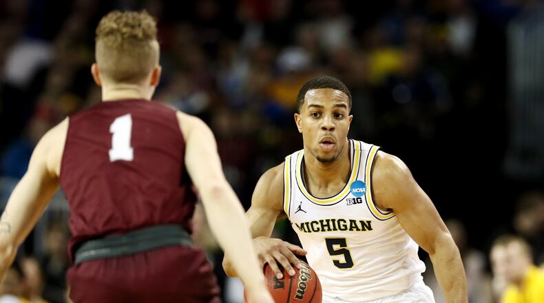 Michigan’s Jaaron Simmons, right, is defended by Montana’s Timmy Falls during the first half of the first round of the NCAA tournament on March 15, 2018 in Wichita, Kansas. Photo by Jamie Squire/Getty Images