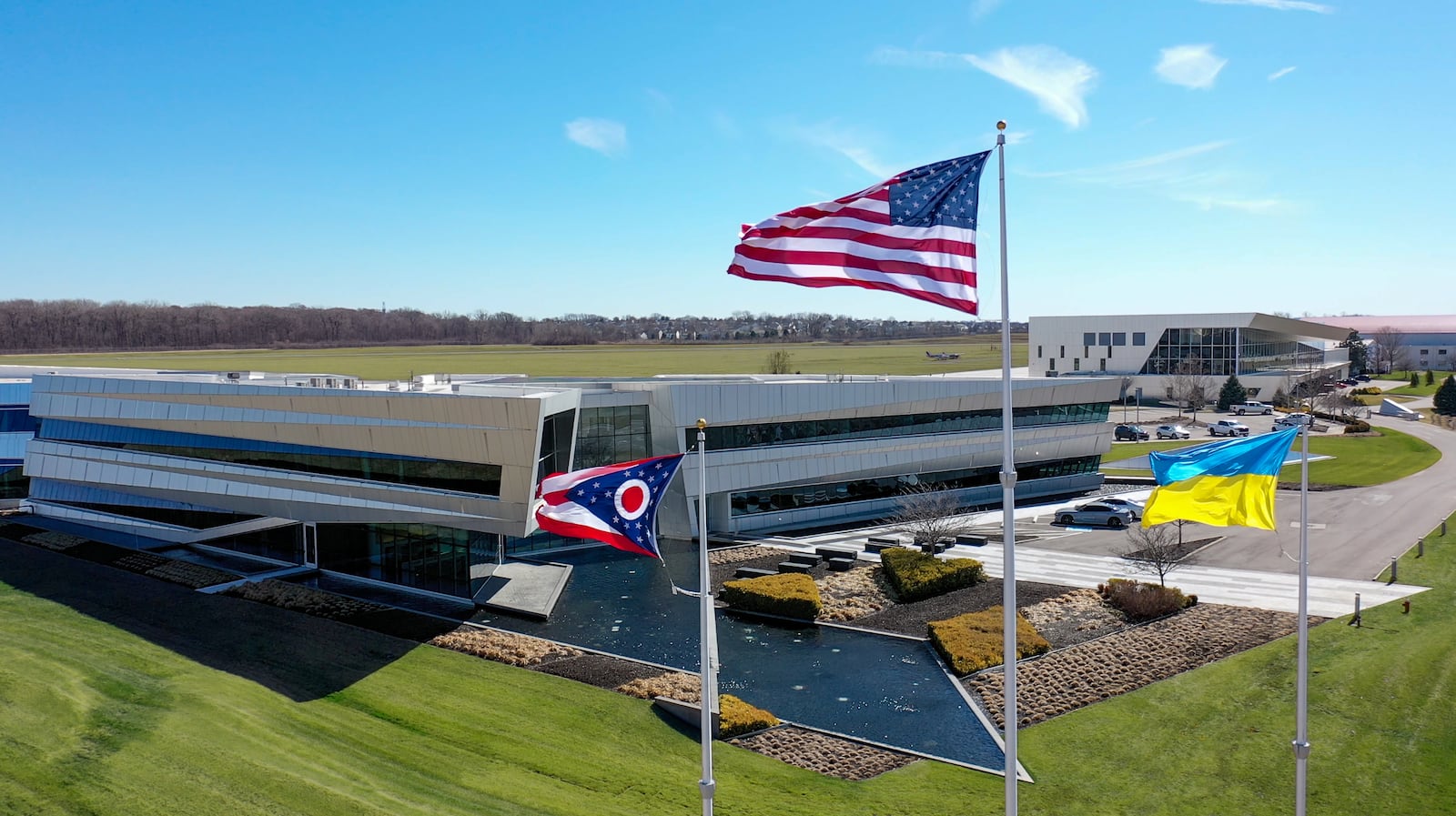 The blue and yellow Ukrainian flag flies alongside the stars and stripes of the U.S. flag and the swallowtail-design Ohio flag outside The Connor Group headquarters on Springboro Pike in Miami Township. (Contributed Photo)