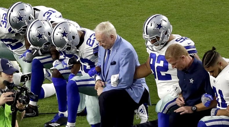 In this Sept. 25, 2017, photo, the Dallas Cowboys, led by owner Jerry Jones, center, take a for the national anthem prior to an NFL football game against the Arizona Cardinals, in Glendale, Ariz. President Donald Trump's clash with the scores of professional football players who knelt during the "Star Spangled Banner" last weekend has set off a heated debate over proper etiquette during the national anthem. (AP Photo/Matt York, File)