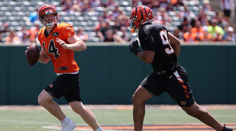 Cincinnati Bengals quarterback Andy Dalton (14), left, rolls out of the pocket as Cincinnati Bengals defensive end Jordan Willis (99) defends during Cincinnati Bengals training camp practice, Saturday, Aug. 5, 2017, at Paul Brown Stadium in Cincinnati. (Kareem Elgazzar/The Cincinnati Enquirer via AP)