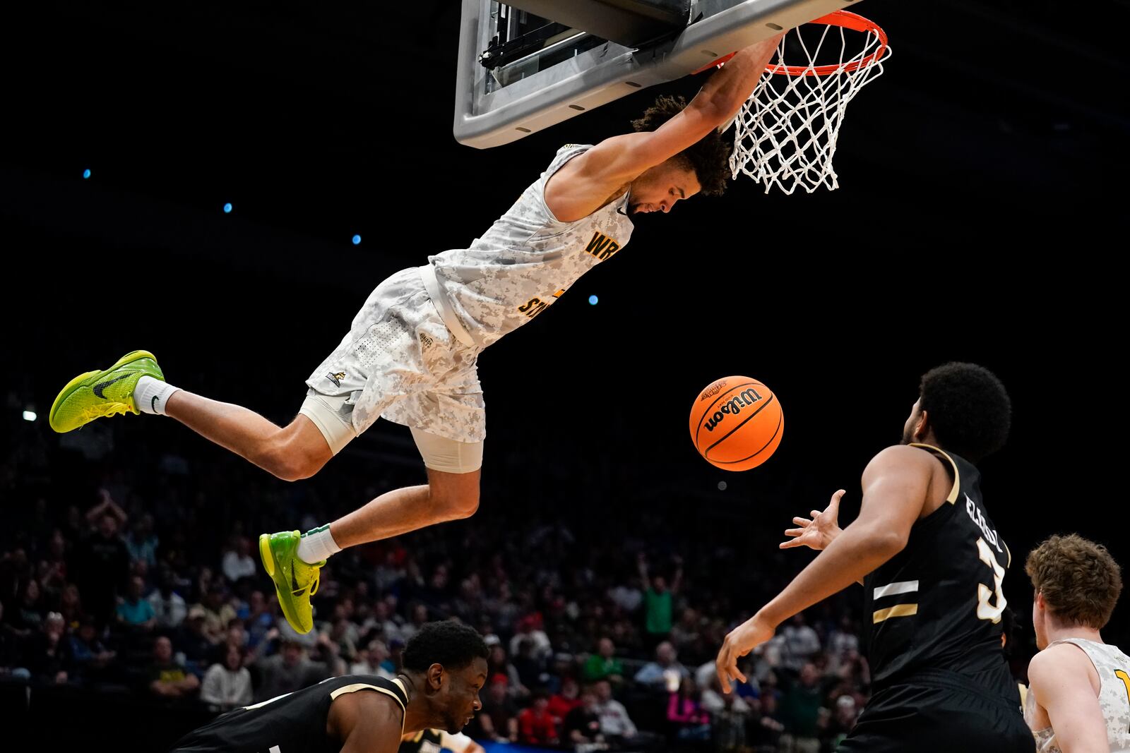 Wright State guard Tanner Holden (2) hangs from the rim after a dunk during the second half of a First Four game in the NCAA men's college basketball tournament against Bryant, Wednesday, March 16, 2022, in Dayton, Ohio. (AP Photo/Jeff Dean)
