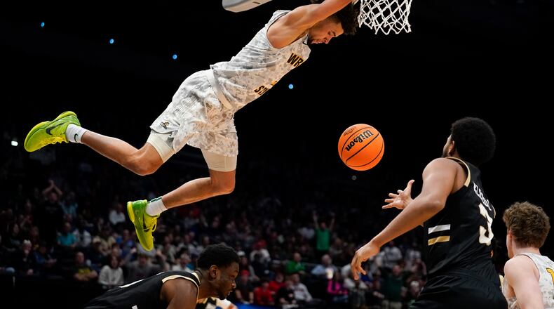 Wright State guard Tanner Holden (2) hangs from the rim after a dunk during the second half of a First Four game in the NCAA men's college basketball tournament against Bryant, Wednesday, March 16, 2022, in Dayton, Ohio. (AP Photo/Jeff Dean)