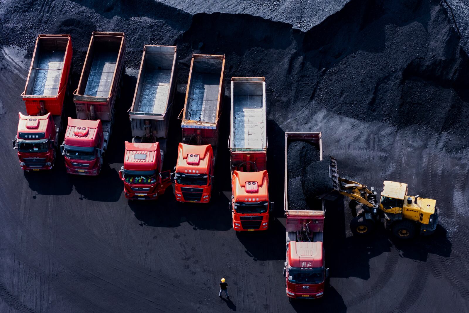 Workers load coal on trucks at a coal yard port on the Yangtze River in southwest China's Chongqing Municipality on Sunday, April 20, 2025. (Chinatopix Via AP)