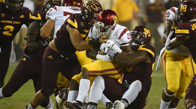 TEMPE, AZ - SEPTEMBER 26: Aca’Cedric Ware #28 of the Southern California Trojans is tackled by Salamo Fiso #58 and Renell Wren #95 of the Arizona State University Sun Devils during the second half at Sun Devil Stadium on September 26, 2015 in Tempe, Arizona. Trojans won 42-14. (Photo by Norm Hall/Getty Images)
