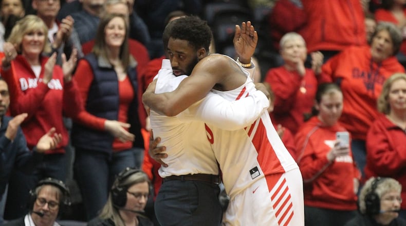 Dayton’s Josh Cunningham hugs Anthony Grant after leaving the court in his final home game against La Salle on Wednesday, March 6, 2019, at UD Arena. David Jablonski/Staff