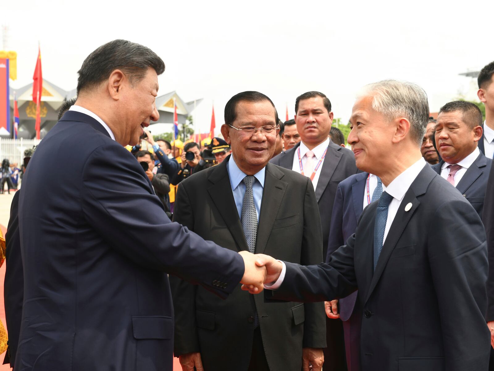 In this photo released by Agence Kampuchea Press (AKP), Chinese President Xi Jingping, left, shakes hands with his ambassador to Cambodia Wang Wenbin, right, as Cambodian Senate President Hun Sen, center, looks on during a send-off ceremony at Phnom Penh International Airport in Phnom Penh, Cambodia, Friday, April 18, 2025. (AKP via AP)
