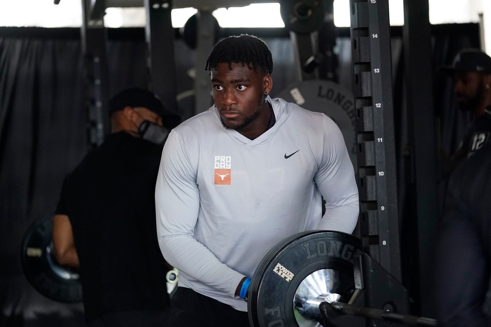 FILE - In this March 11, 2021, file photo, Texas linebacker Joseph Ossai prepares to lift weights for scouts and coached during the school's Pro Day in Austin, Texas. Ossai was Ossai was the third round pick by the Cincinnati Bengals in the NFL football draft. (AP Photo/Eric Gay, File)