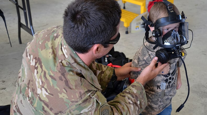 A protective mask is fitted onto a military-dependent child during a mock deployment exercise. The mock exercise helps children to better understand the deployment process that their parents go through. The Airman & Family Readiness Center provides resources and assistance to deployed families through Hearts Together events under the Family Readiness program. (Contributed photo)