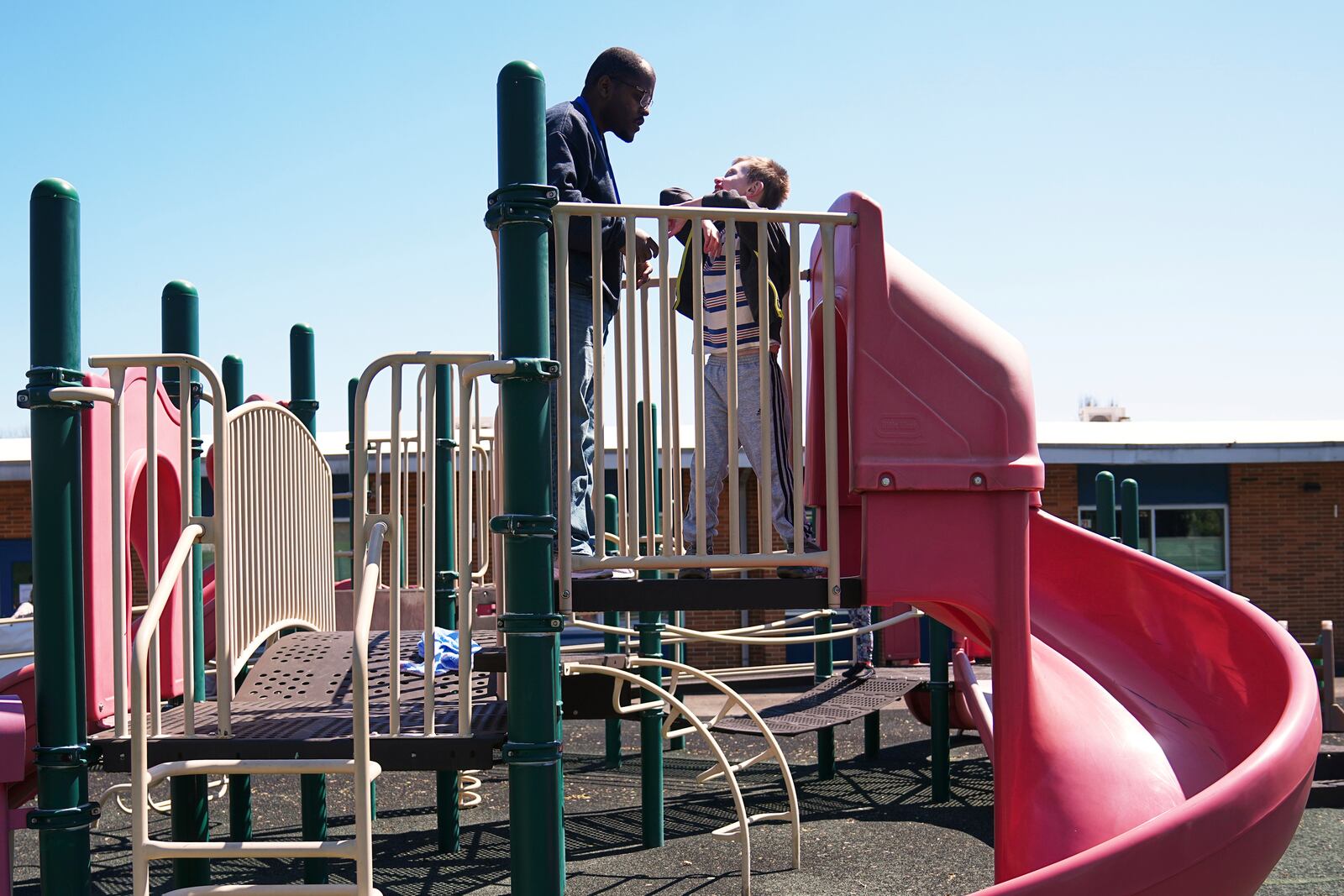 Mark moves about on a playground apparatus accompanied by paraprofessional Raheem Morton at Archbishop Damiano School in Westville, N.J., Wednesday, April 9, 2025. (AP Photo/Matt Rourke)