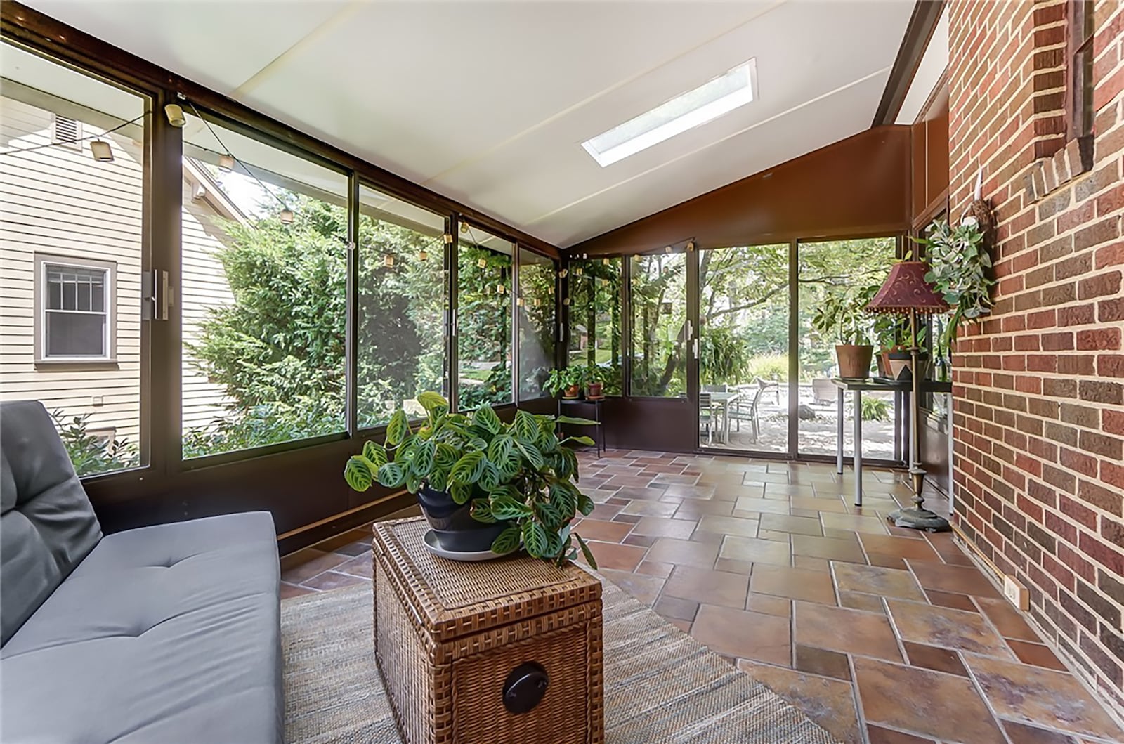 The sunroom has tile floors and two skylights. Exterior doors open to the paver patio. CONTRIBUTED