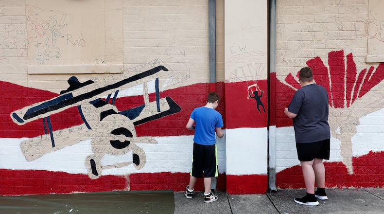 A mural going up along TNT Midwest Martial Arts Academy in Fairborn is not only a tribute to the city's military aviation history, but a positive outlet for kids involved in Greene County Juvenile Courts. MARSHALL GORBY\STAFF