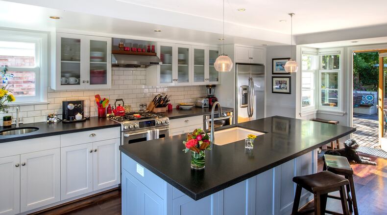 The Livingstons’ kitchen, remodeled and enlarged seven years ago, spills out onto the new back deck behind Georgia, the family dog. “We really wanted to make this connection with the deck at the same level,” says associate architect John Geurts. “It’s a terrific yard.” (Mike Siegel/Seattle Times/TNS)