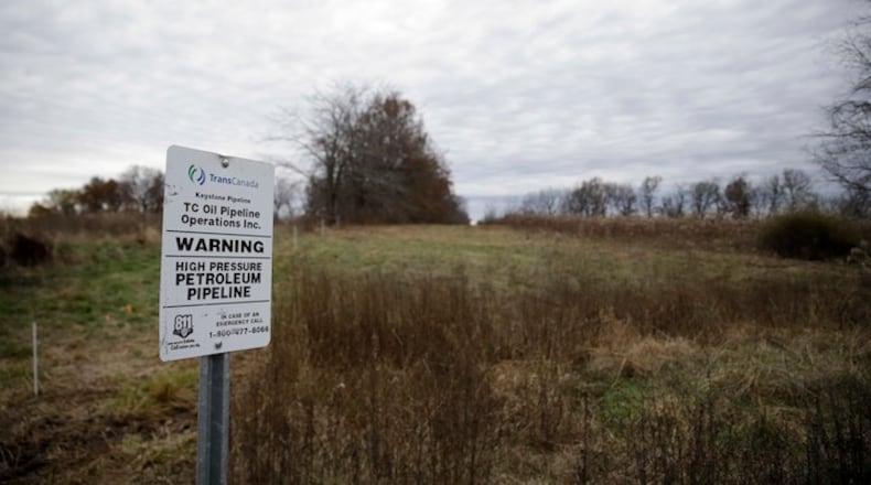 In this Nov. 20, 2015 file photo, a sign marking the location of the TransCanada Keystone underground oil pipeline, running under farmland is seen in Moberly, Mo. (AP Photo/Jeff Roberson, File)