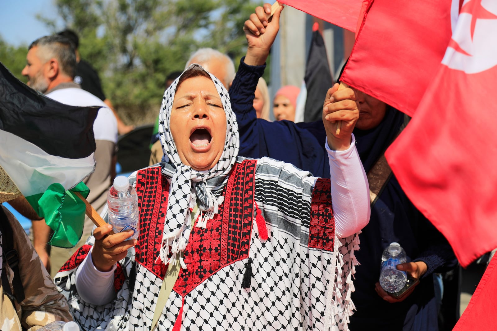 Members of a humanitarian convoy of at least 1,500 people, including activists and supporters from Algeria and Tunisia, shout pro-Palestinian slogans as they gather, on their way to Gaza via Egypt's Rafah Crossing, in Zawiya, Libya, Tuesday, June 10, 2025. (AP Photo/Yousef Murad)