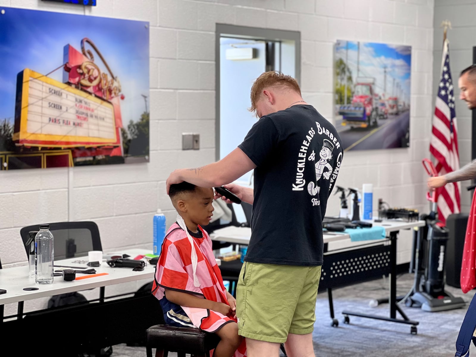 A barber with Knuckleheads Barber Company volunteered his time to give back-to-school hair cuts at the Harrison Twp. event. AIMEE HANCOCK/STAFF