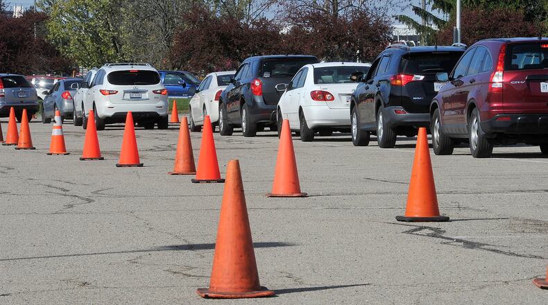 FILE PHOTO: Vehicles follow a course through the Wright State's Nutter Center parking lot Tuesday to receive food from the Dayton Food Bank. MARSHALL GORBY\STAFF