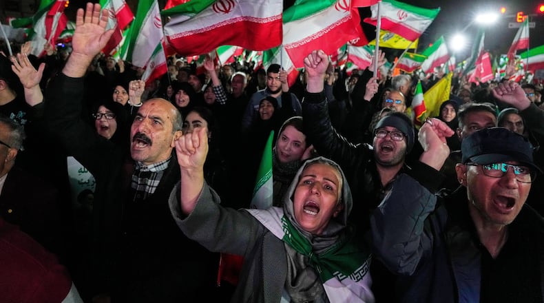 Pro-government supporters chant slogans and wave Iranian flags during a rally, in a square in western Tehran, Iran, Wednesday, March 25, 2026. (AP Photo/Vahid Salemi)