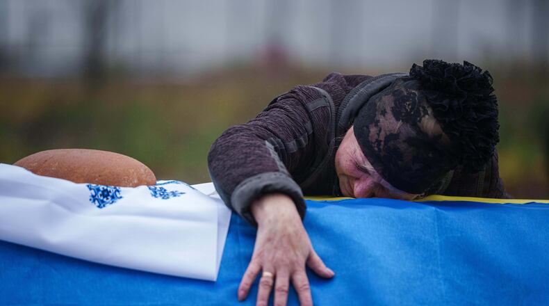 A mother cries at the coffin of her son Oleh Borovyk, a Ukrainian serviceman who was killed in fighting with Russian forces near Pokrovsk, during his funeral ceremony in Boiarka, Ukraine, on Wednesday, Dec. 3, 2025. (AP Photo/Evgeniy Maloletka)