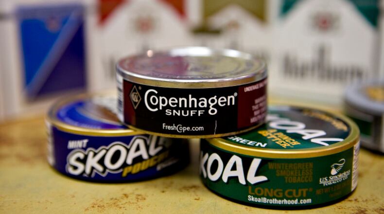Cans of Skoal and Copenhagen brand smokeless tobacco sit on display in front of Marlboro and Parliament brand cigarettes in a deli in New York, U.S., on Thursday, Jan. 28, 2010. Altria Group Inc., the largest U.S. tobacco company, said fourth-quarter profit rose 6.8 percent, bolstered by the acquisition of snuff maker UST Inc. Photographer: Daniel Acker/Bloomberg via Getty Images