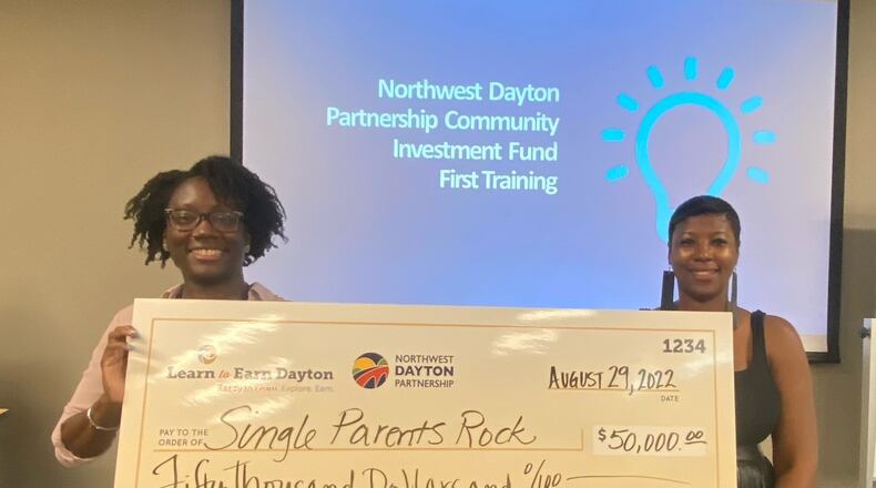 Learn to Earn Dayton's Nina Carter (left) presents a $50,000 grant to Denise Henton for the group Single Parents Rock. Learn to Earn's Northwest Dayton Partnership issued $1.45 million in grants to 28 groups that applied. CONTRIBUTED PHOTO