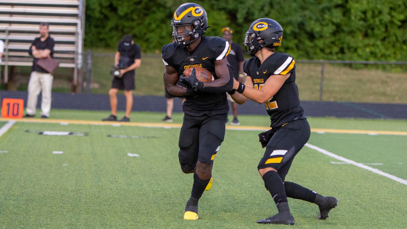 Centerville's Emable Wakilongo takes a handoff from quarterback Drake Wells against Dublin Coffman. CONTRIBUTED/Jeff Gilbert