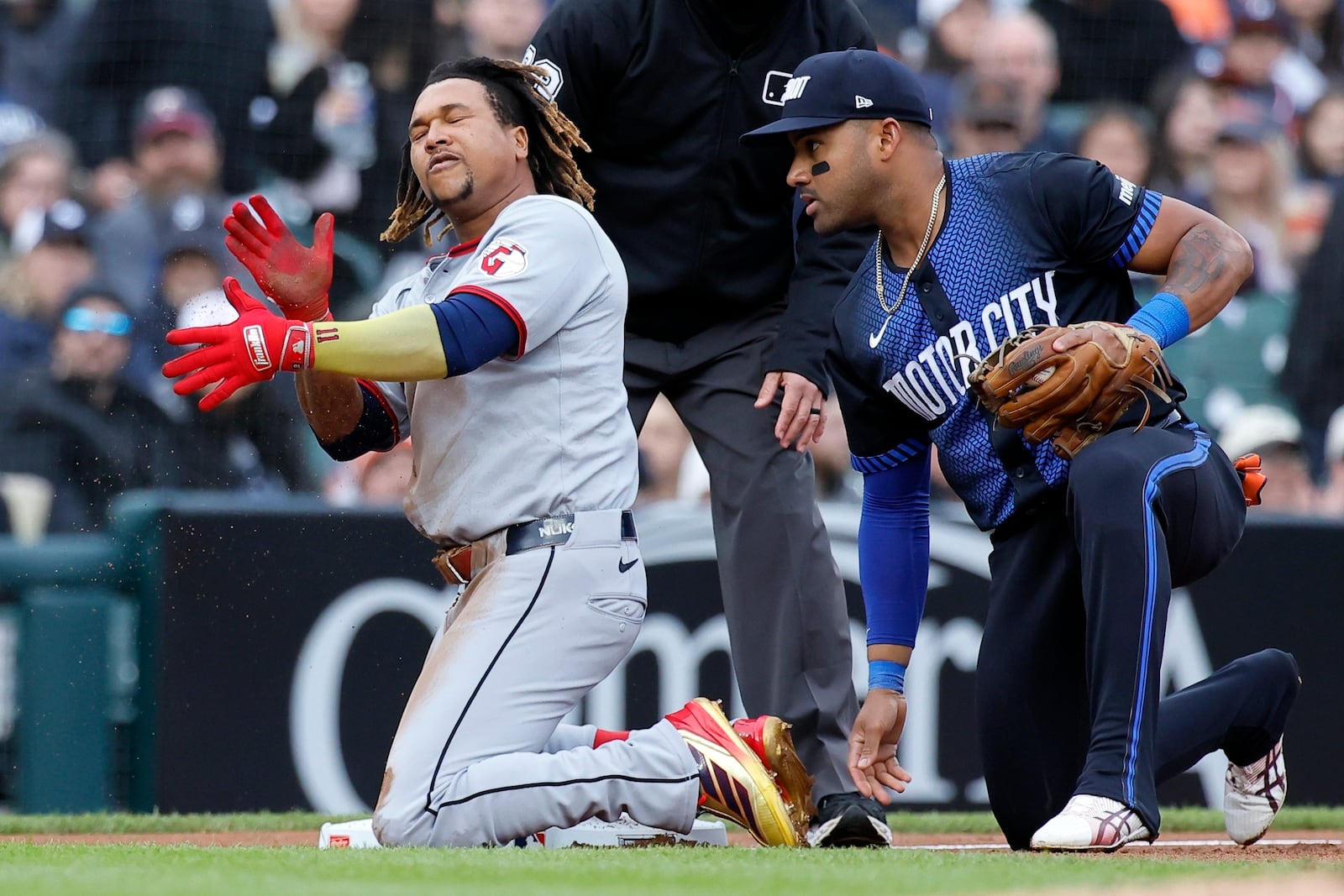 Cleveland Guardians' José Ramírez, left, celebrates after his triple that drove in Steven Kwan in front of third baseman Detroit Tigers' Andy Ibáñez, right, during the first inning of a baseball game Friday, May 23, 2025, in Detroit. (AP Photo/Duane Burleson)