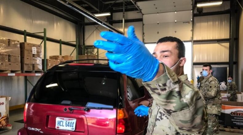 The Ohio National Guard helps direct traffic during a July 23, 2020, drive-thru food distribution event at The Foodbank in Dayton. STAFF