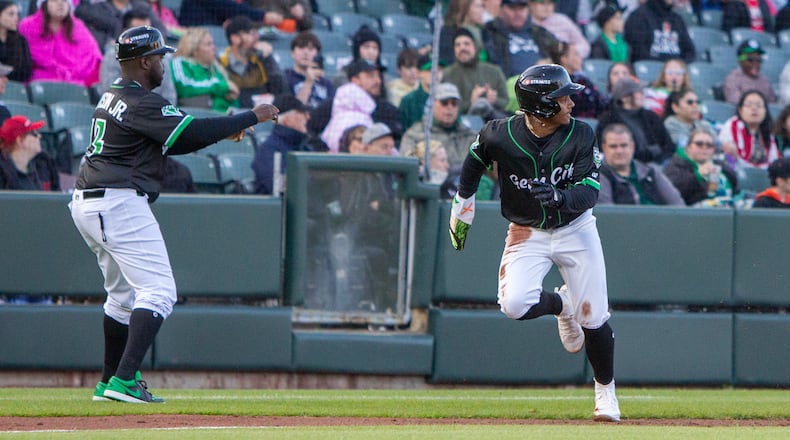 Dayton's Victor Acosta is waved home by manager Vince Harrison Jr. after a throwing error by the catcher earlier this season at Day Air Ballpark. Jeff Gilbert/CONTRIBUTED